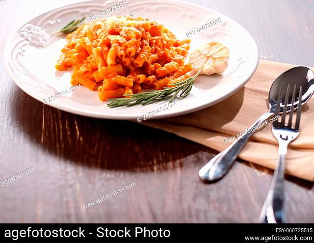 Italian pasta with tomato cheese and garlic. Close-up on a plate with melted cheese