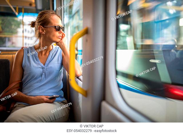 Young woman on a city tram, heading for the office early, before the rush hour begins