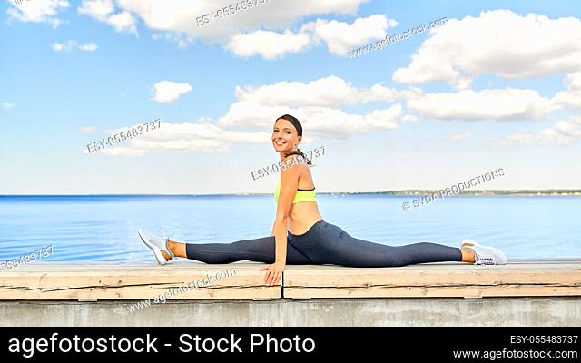 young woman doing full split at seaside