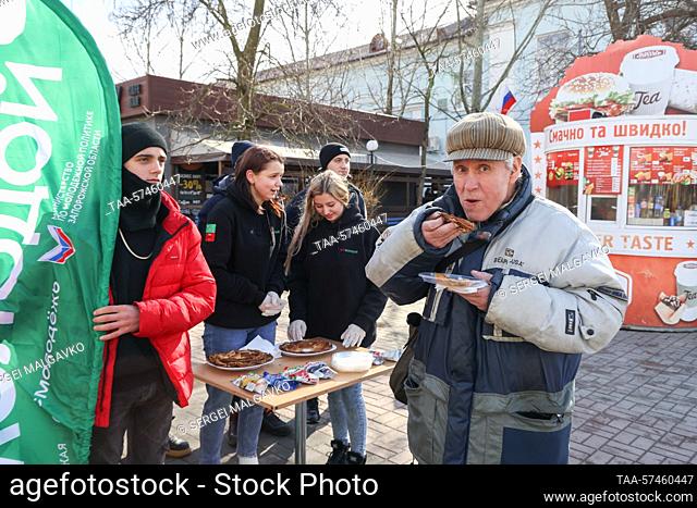RUSSIA, BERDYANSK - FEBRUARY 20, 2023: Activists of the Young South public organization give out blini, traditional Russian pancakes