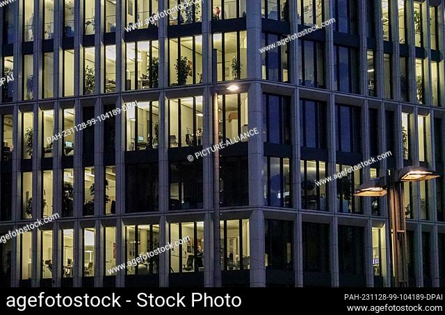 27 November 2023, Saxony, Leipzig: The offices in a building in the city center are brightly lit in the evening. Photo: Jan Woitas/dpa