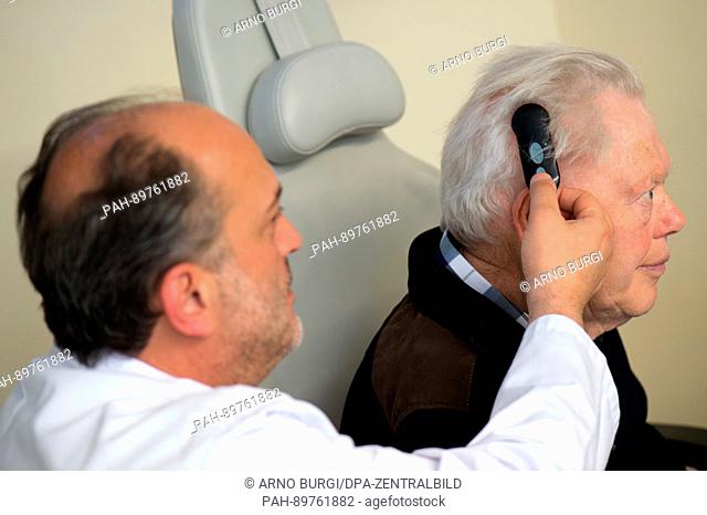 Otorhinolaryngologist Nikoloz Lasurashvili (l) explains the fuction of a remote control for a fully implanted hearing aid to patient Juergen Schmidt (76) during...