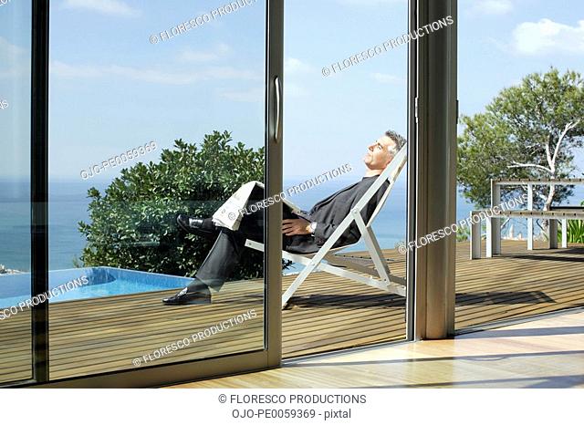Man sleeping on deck by infinity pool