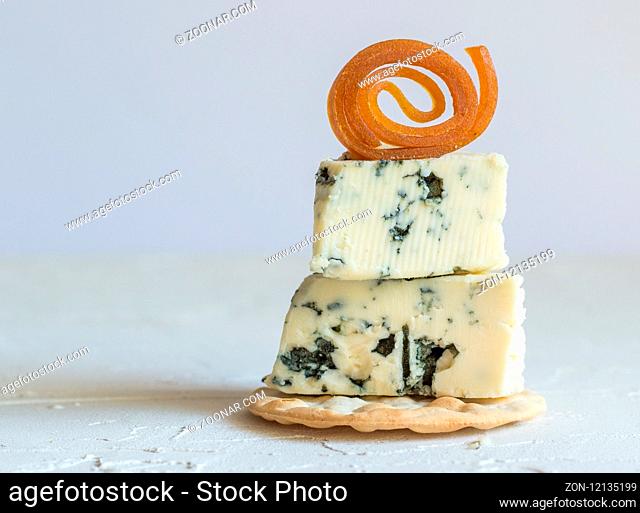 Blue cheese on cracker with candied peach roll decoration