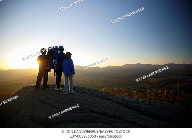 Family watching sunset on top of The Pinnacle, Stowe, Vermont, USA