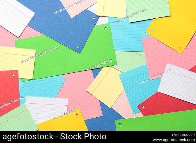 Vibrant background with a multitude of paper notes spread on an office desk