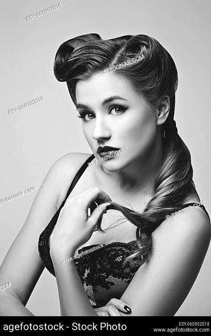 Beautiful retro pinup girl with red lips in black lace lingerie. Studio shot. Copy space. Monochrome