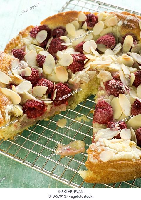 Raspberry Almond Cake with a Slice Removed on Cooling Rack