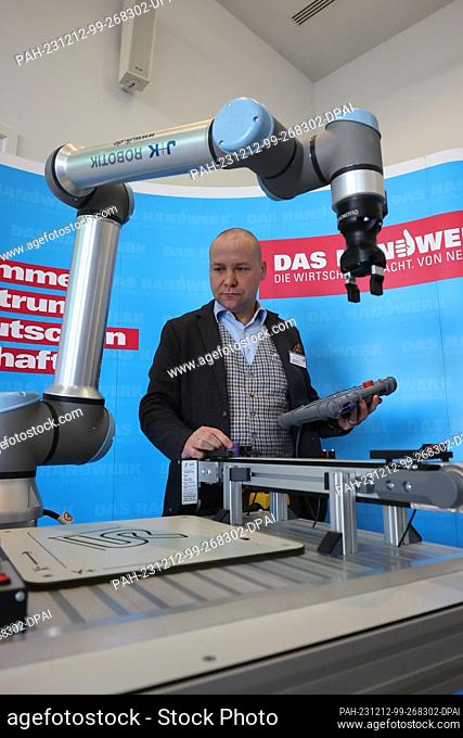 12 December 2023, Thuringia, Erfurt: Christian Held from Jugard+Künstner works at a robotics learning station at the kick-off event for the Competence Center...