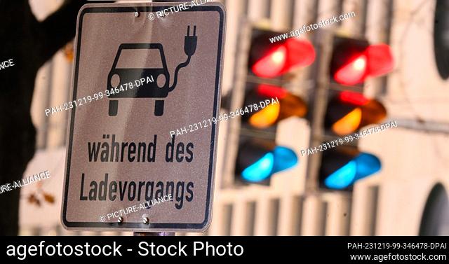 19 December 2023, Lower Saxony, Hanover: A sign with a symbol for an electric car and the words ""while charging"" marks a parking space at a charging station