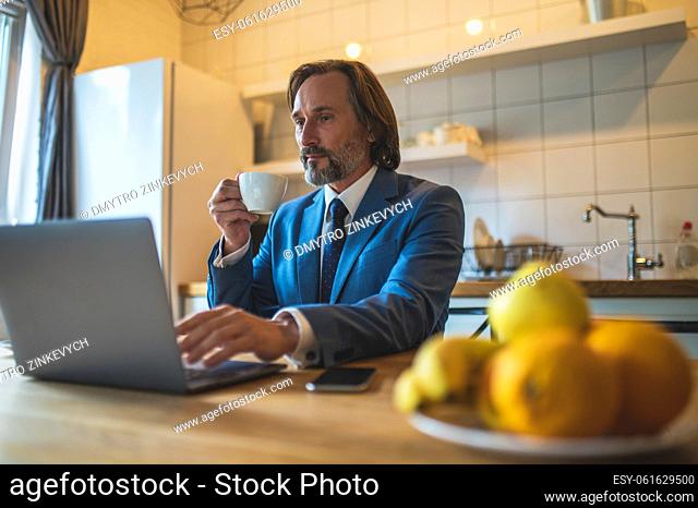 Video call. Man in blue jacket working in the home office and having a video call