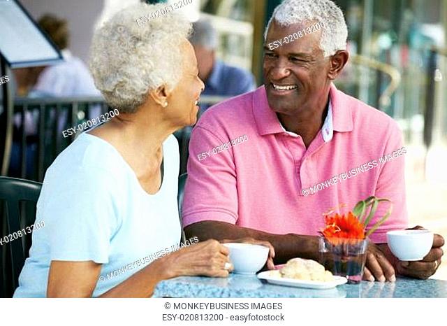 Senior Couple Enjoying Snack At Outdoor Café