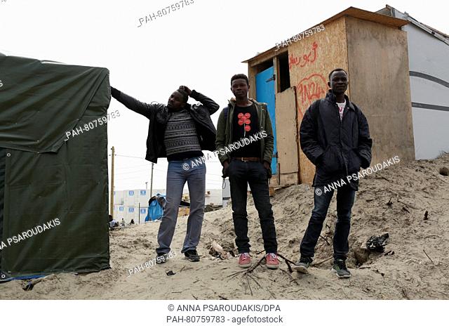 Sudanese men contemplate the burned landscape in the migrant camp dubbed the 'Jungle' on the outskirts of Calais, France, 27 May 2016