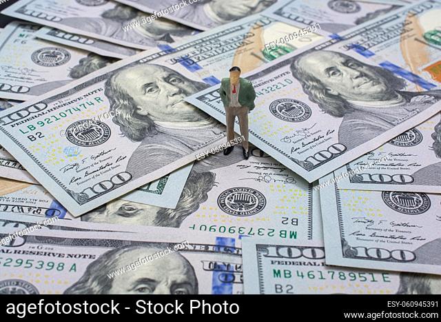 One Hundred Dollar American Banknotes and man figurine