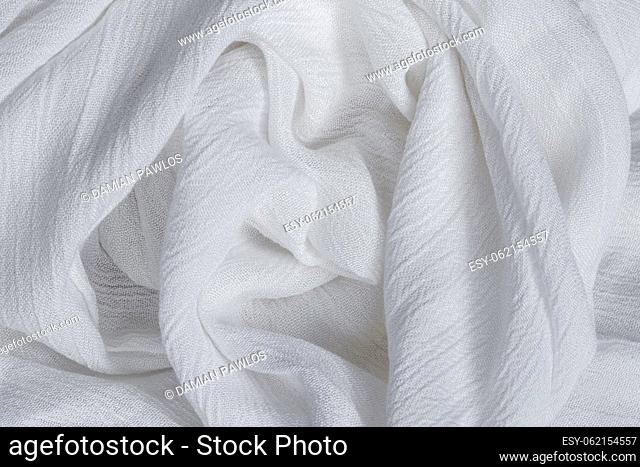 Wrinkled white viscose fabric. Artificial fiber from natural wood pulp. Textile texture as background