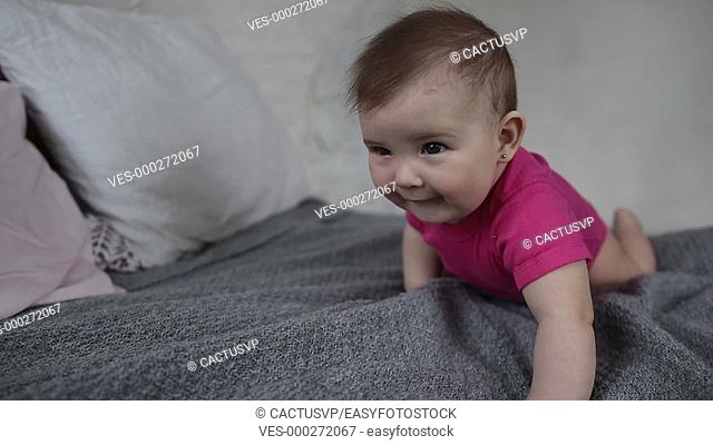 Laughing newborn child playing on bed