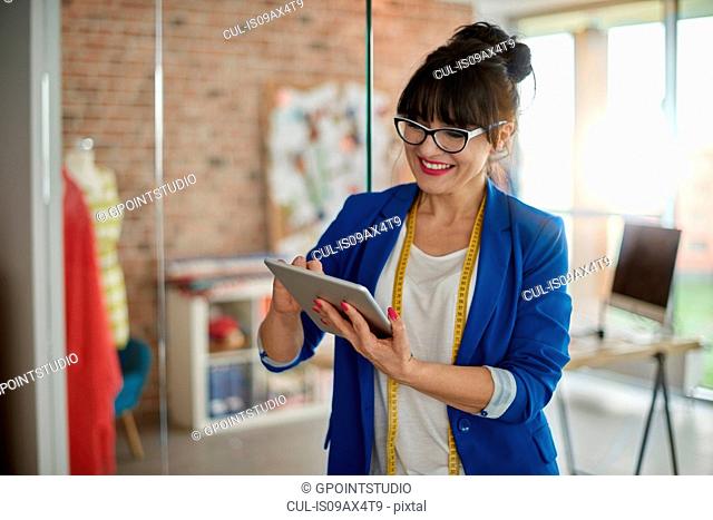 Woman in design studio using digital tablet smiling