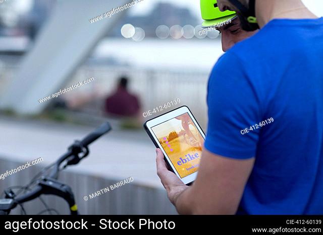 Men with digital tablet renting bicycle with mobile app