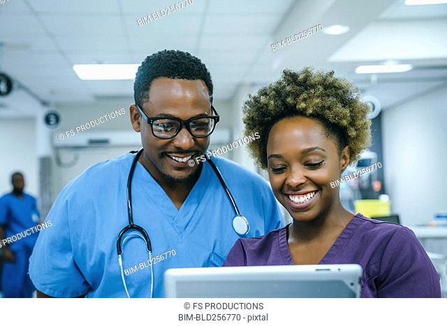 Smiling black nurses using digital tablet