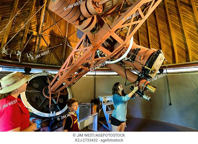 Flagstaff, Arizona - Visitors to the Lowell Observatory view the 13-inch astrograph telescope in the Pluto Telescope Dome