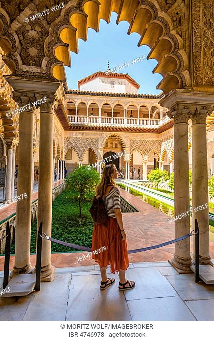 Woman in a Red Dress, Patio de las Doncellas, Court of the Maidens, an Italian Renaissance courtyard, with stucco arabesques in Mudejar style, Alcazar