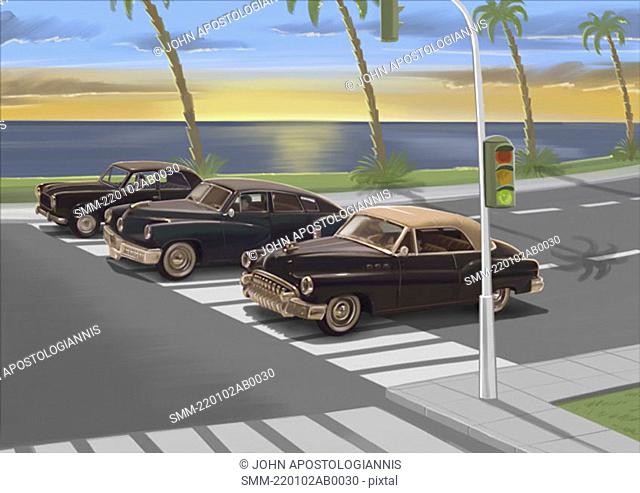 Three vintage black cars waiting at traffic light
