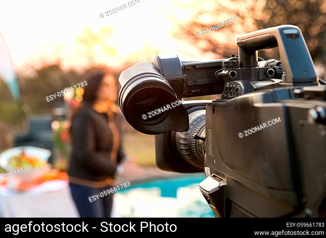 TV Camera and presenter host on a live news broadcast on location at sunrise