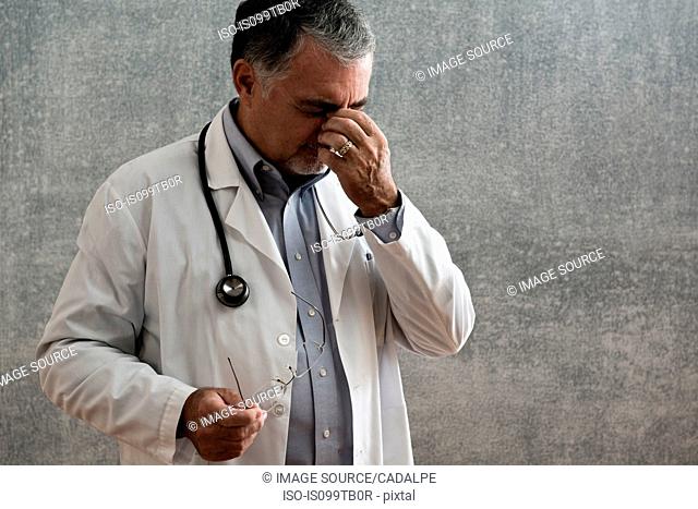 Male doctor looking stressed