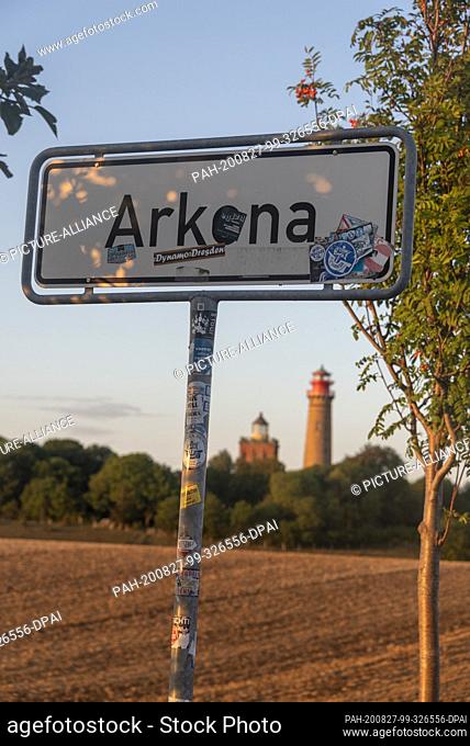 19 August 2020, Mecklenburg-Western Pomerania, Putgarten: Street sign with the writing Arkona. In the background new lighthouse Kap Arkona (r) and the...