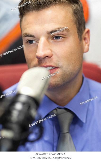 Well dressed concentrating radio host moderating