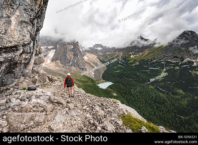 Young woman, hiker on a fixed rope route, Via ferrata Vandelli, Sorapiss circuit, mountains with low clouds, Dolomites, Belluno, Italy, Europe