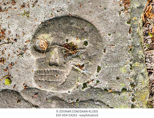 Usqurt, The Netherlands - August 19, 2012: Skull in a gravestone on a graveyard in Usquert in the province of Groningen