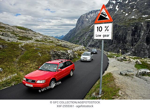 Cars passing a road sign warning of a steep road grade on the Trollstigen National Tourist Route, Møre og Romsdal, Vestland, Norway