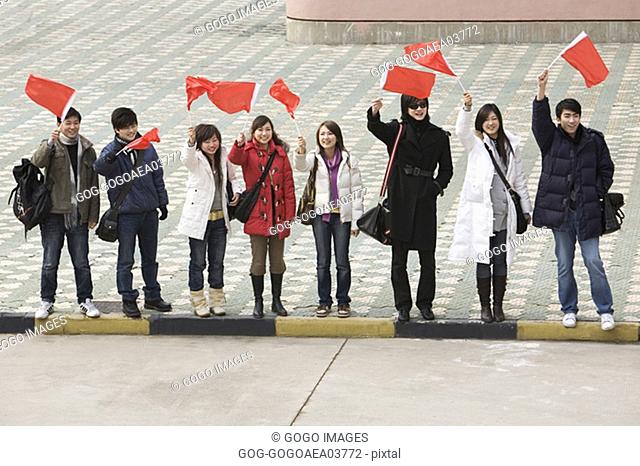 High-angle view of people waving red flags at curb
