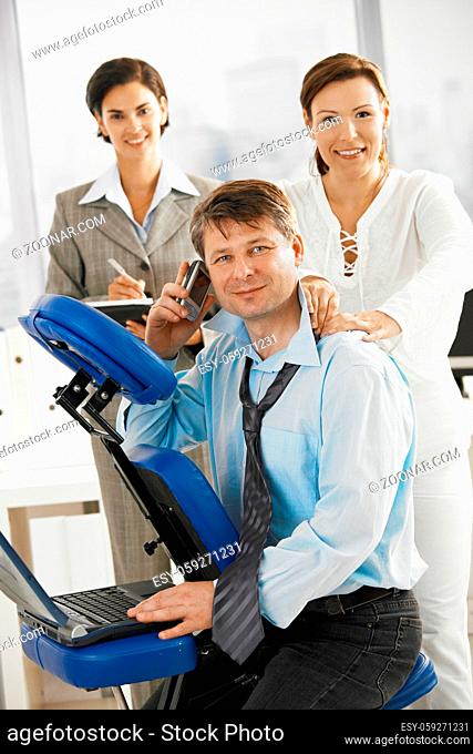 Occupied executive continue working while getting back massage in office