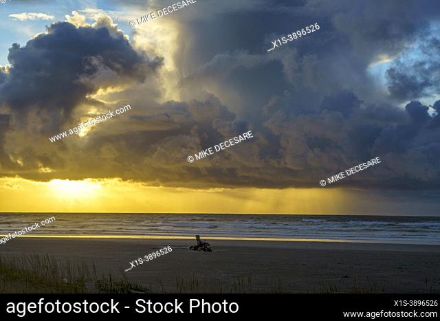 An evening storm competes with a spetacular sunet set along the beach in Seaside, Oregon, and rain isn't far off