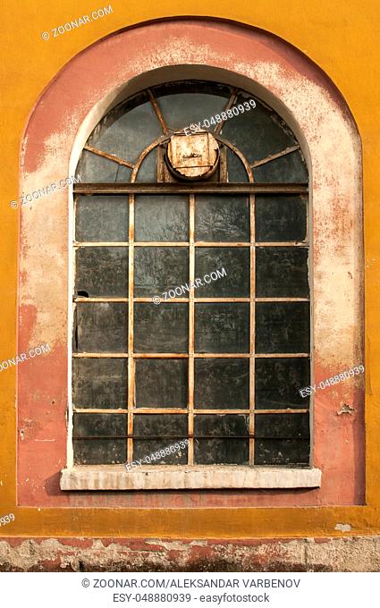 Old vintage weathered crumbling grunge glass window of abandoned industrial building