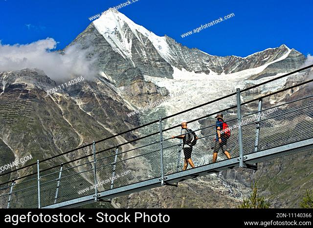 Wanderer im Abstieg auf der Charles Kuonen Hängebrücke, die längste Fussgänger-Hängebrücke der Welt, vor dem Weisshorn Gipfel, Randa, Wallis