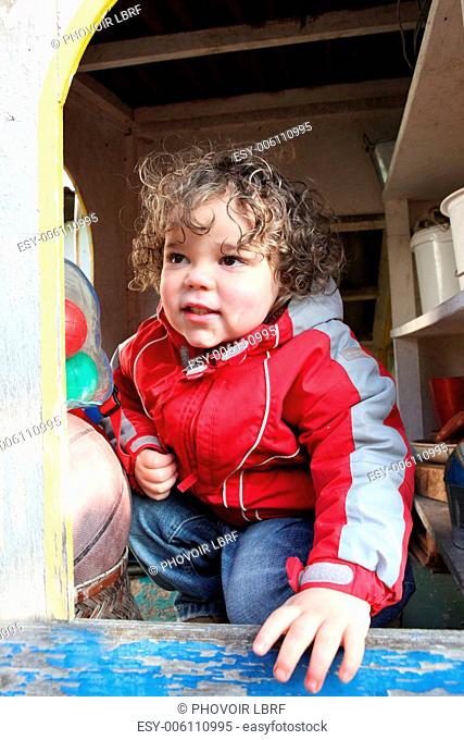 Little boy playing in garden shed
