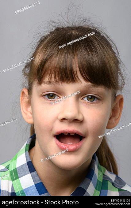Portrait of a funny ten-year-old girl with wide mouth, European appearance, close-up