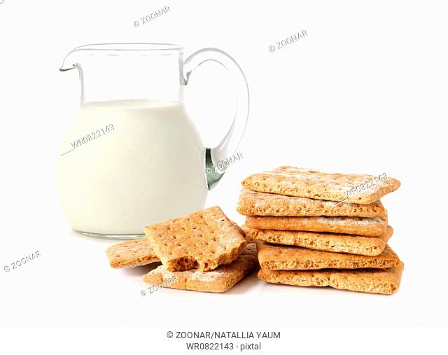 Glass jug with milk and cracker