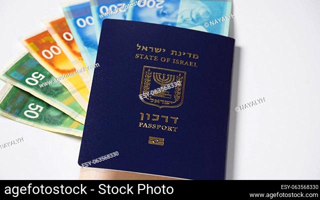 Blue Israeli passport (darkon). Passport with gold stamping Biometric sign and colorful Israeli banknotes