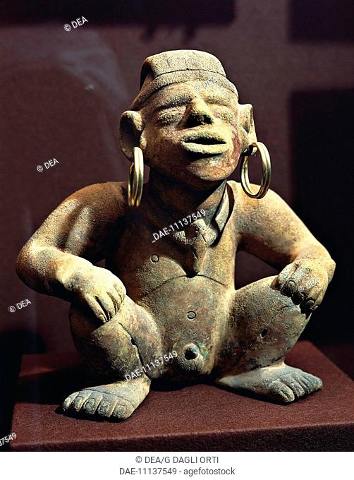 Pre-Columbian civilization, Colombia, 10th century A.D. Terracotta male statuette with golden earrings. From Calima.  Bogotá