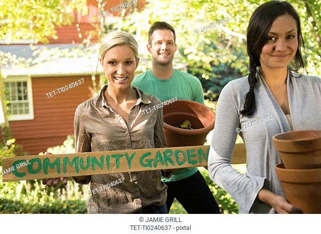 Three friends preparing community garden