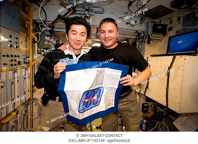 Japanese astronaut Kimiya Yui (left) and NASA astronaut Kjell Lindgren (right) celebrate 100 days in space. The pair received a commemorative patches for the...
