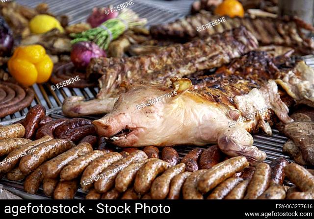 Detail of roasted pork on the charcoal grill, unhealthy and greasy meat