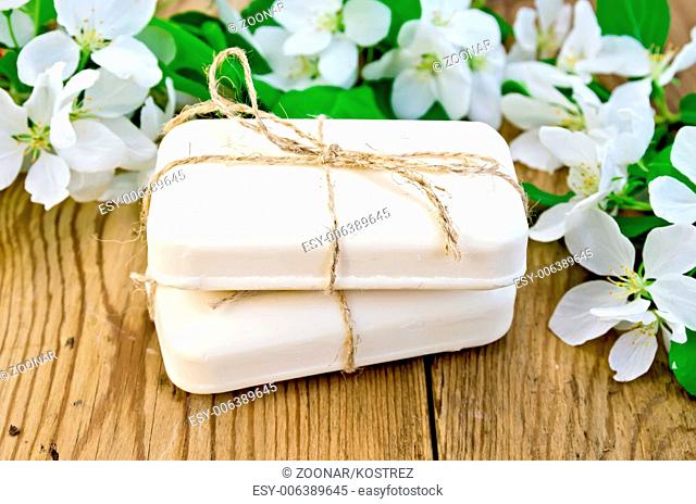 Soap with white flowers of apple on board