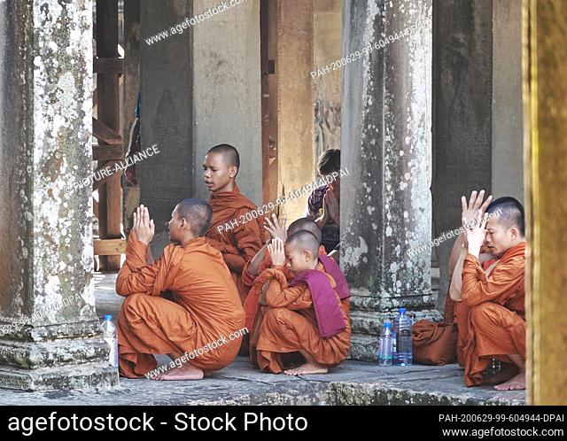 23 October 2019, Cambodia, Siem Reab: Monks praying in an orange cape..in the main temple Angkor Wat. King Suryavarman had the temple