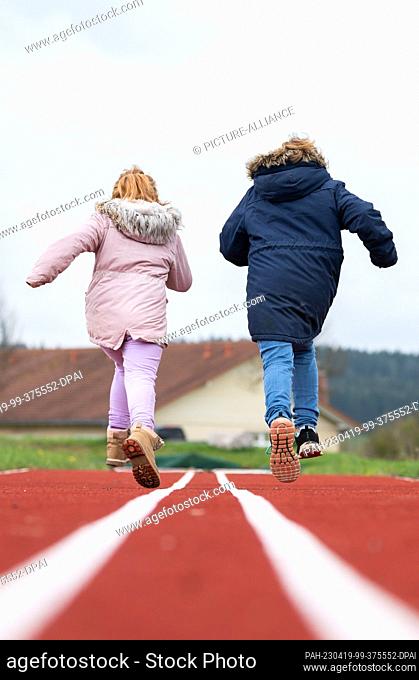 SYMBOL - 19 April 2023, Baden-Württemberg, Rottweil: Children running on a tartan track. Photo: Silas Stein/dpa. - Rottweil/Baden-Württemberg/Germany