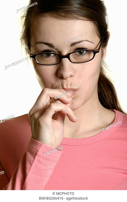 brunette young woman holding putting something eatable into her mouth